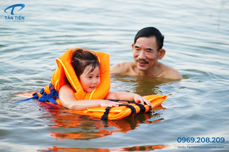 Bé gái mặc áo phao cứu hộ để học bơi