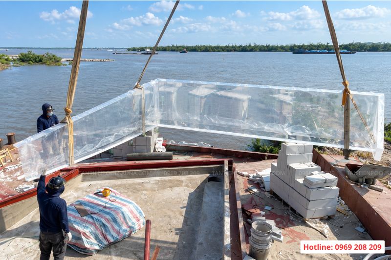 Cẩu và lắp đặt tấm acrylic vào rãnh chờ